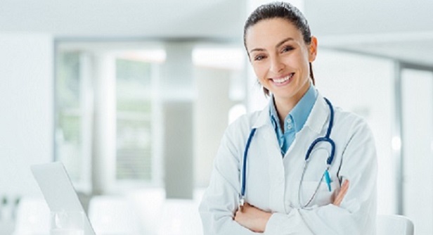 Confident female doctor sitting at office desk and smiling at camera, health care and prevention concept